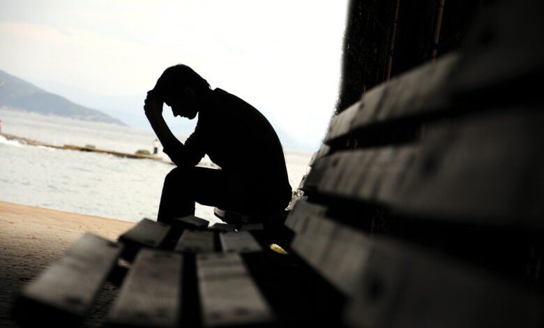 depressed young man sitting on the bench